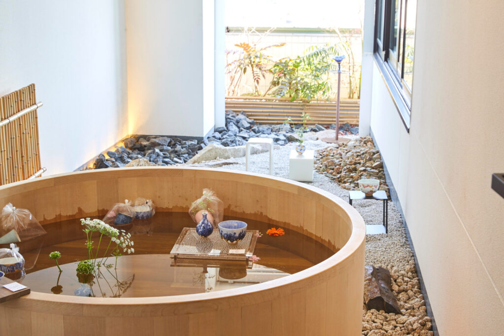 屋外のひばの浴槽を展示スペースにした510号室は、京都瑞鳳堂（加藤美樹さん）の作品で、湯船に花器や草花を浮かべて展示。